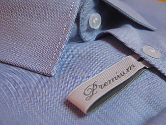Close-up of blue herringbone shirt collar with premium label