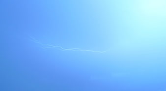 Lightning bolt striking across a blue stormy night sky