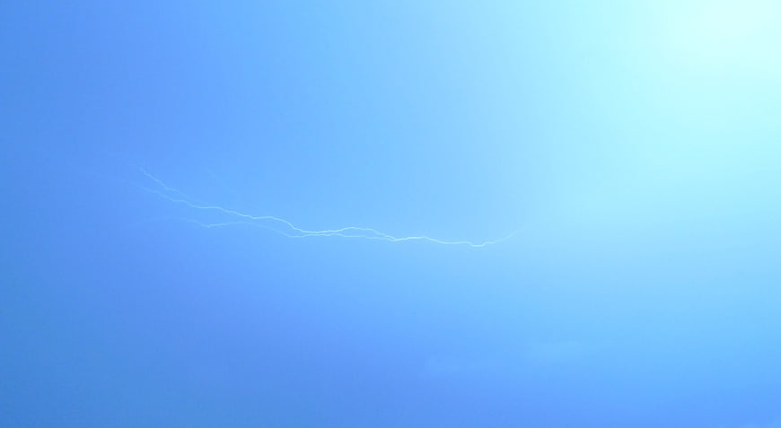 Lightning bolt striking across a blue stormy night sky