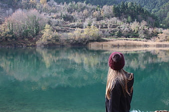Woman in Red Beanie Looking at Turquoise Lake