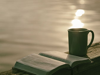 Open Bible and Coffee Mug on Wooden Dock by Lake