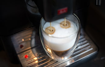 Espresso machine pouring coffee into a glass cup