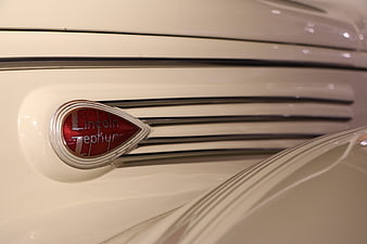 Close-up of vintage Lincoln Zephyr emblem on cream car