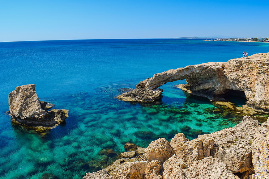 Natural rock arch over turquoise Mediterranean sea