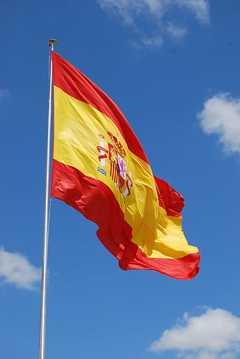 Spanish National Flag Waving Against Blue Sky