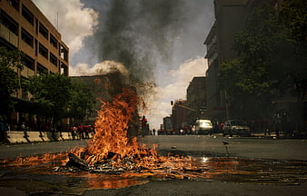 Burning Barricade on City Street with Smoke and Protesters
