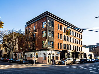 Corner Brick Building on Brooklyn Street with Parked Cars