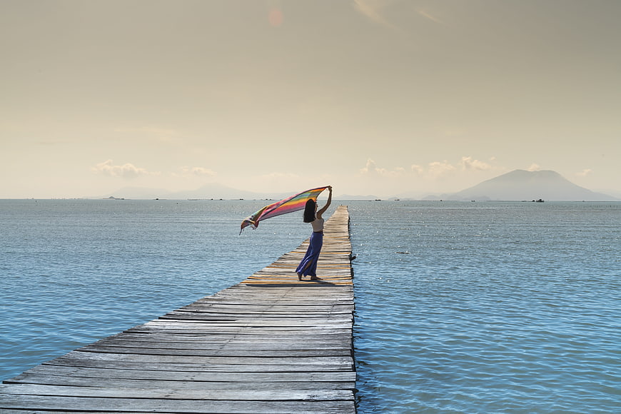 Woman with Rainbow Shawl on Wooden Pier