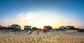 Beach Houses at Sunset with Sand Dunes and Footprints