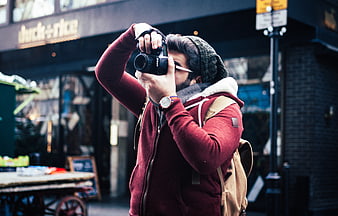 Man with camera taking photo on city street