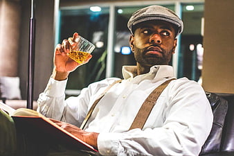 Stylish Man in Cap and Suspenders Drinking Whisky