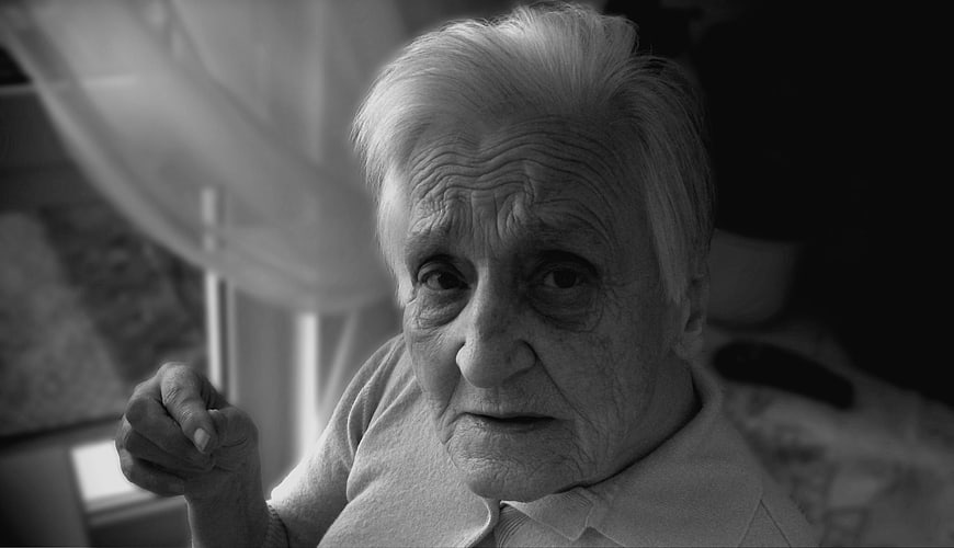 Black and white portrait of elderly woman with dementia in care home