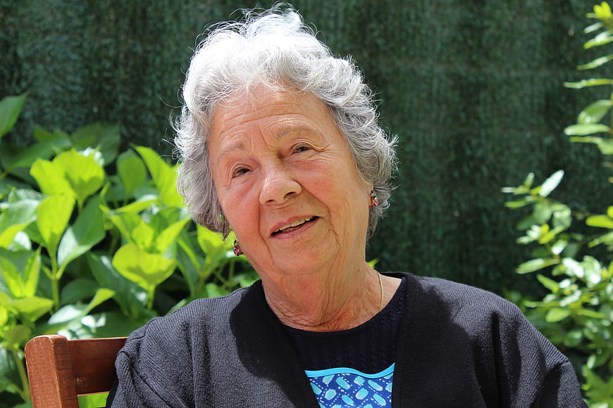 Portrait of smiling elderly woman with gray hair in garden