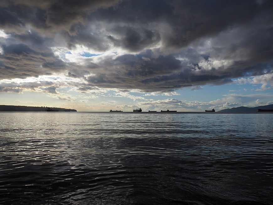 Cargo ships on the ocean under dramatic storm clouds