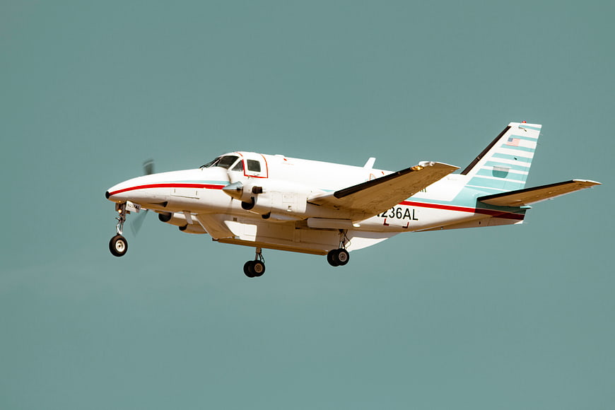 White Propeller Airplane Landing in Blue Sky