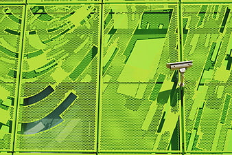 Security Camera on Vibrant Green Perforated Metal Wall