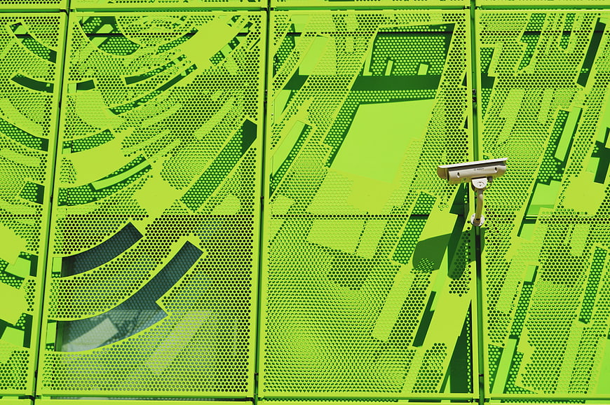 Security Camera on Vibrant Green Perforated Metal Wall