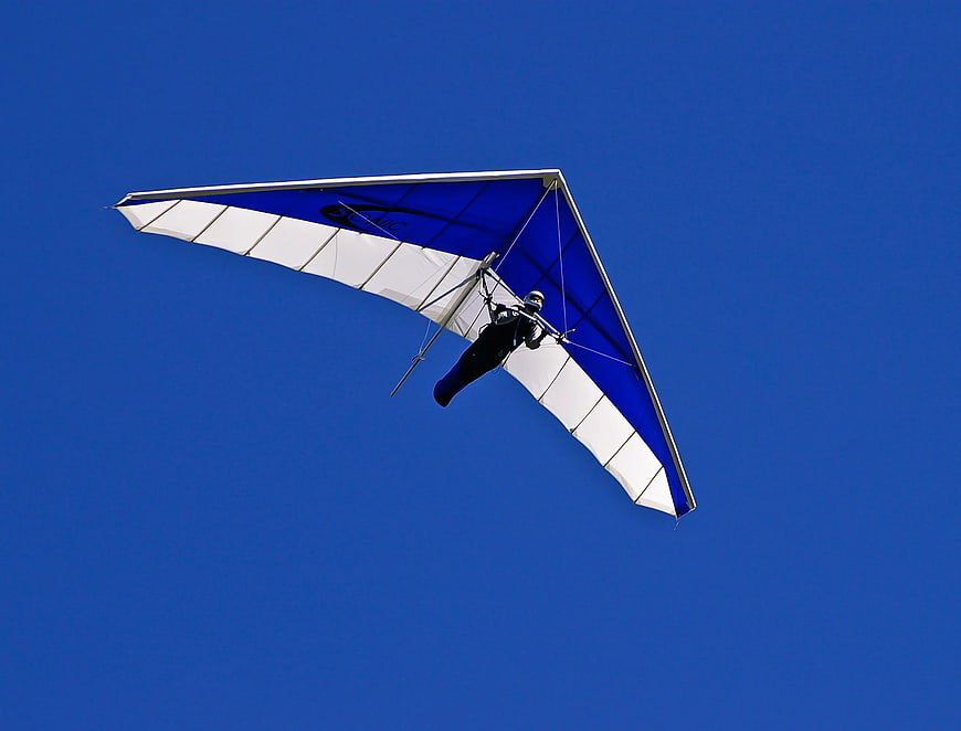 Hang Glider Pilot Soaring in Clear Blue Sky