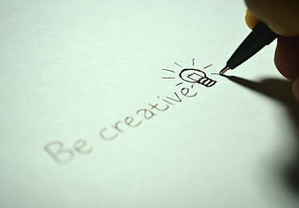 Hand writing be creative with lightbulb drawing on paper