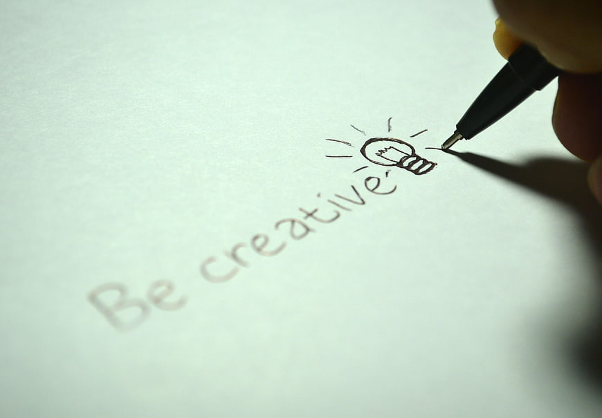 Hand writing be creative with lightbulb drawing on paper