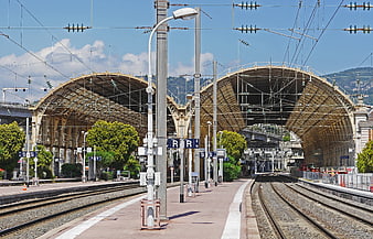 Empty Train Station Platform with Arched Canopy and Tracks