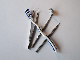 Dental instruments and toothbrush arranged on white background