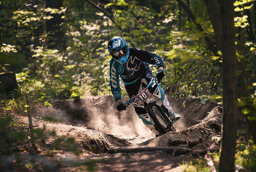 Mountain biker racing downhill on forest trail