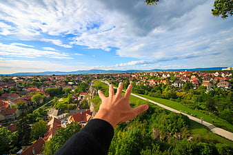 Man's Hand Reaching Over Suburban Town Panorama