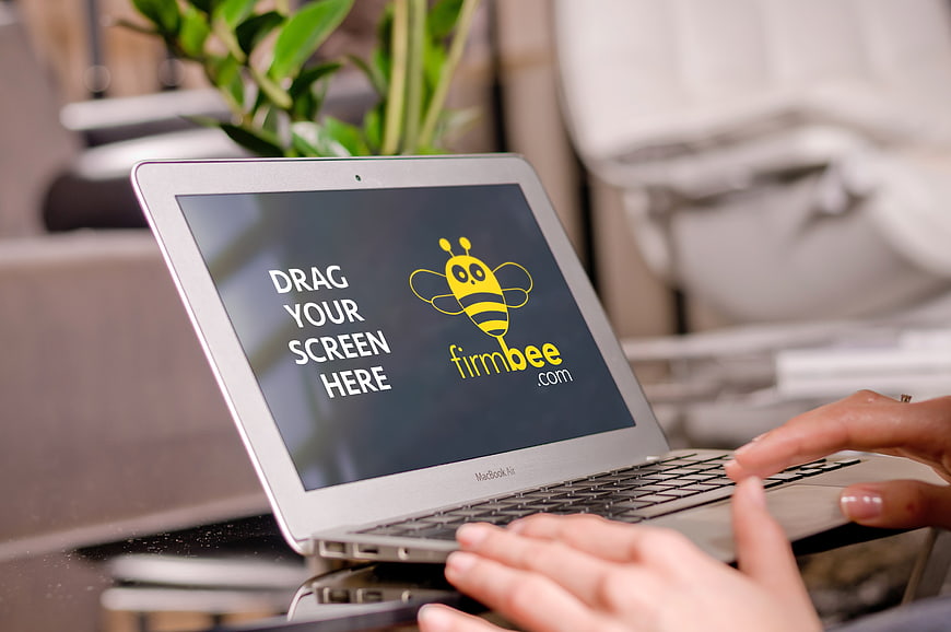 Laptop mockup with hands typing in office workspace