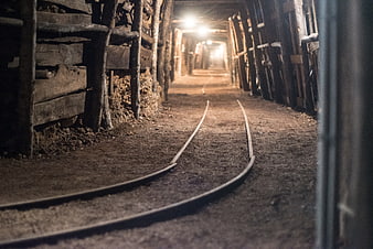 Underground mine tunnel with rails and wooden supports