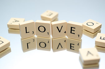 Scrabble Tiles Spelling Love on White Background