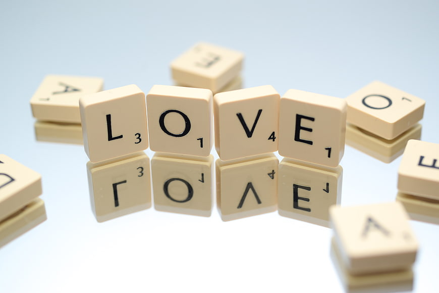 Scrabble Tiles Spelling Love on White Background