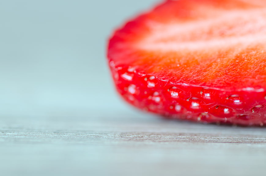 Close-up of fresh sliced strawberry on wooden surface