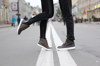 Couple's feet in grey shoes on city street