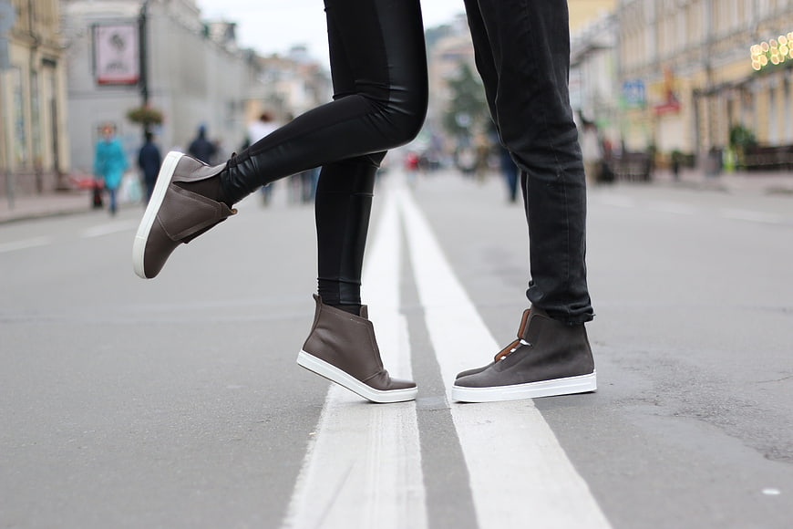 Couple's feet in grey shoes on city street