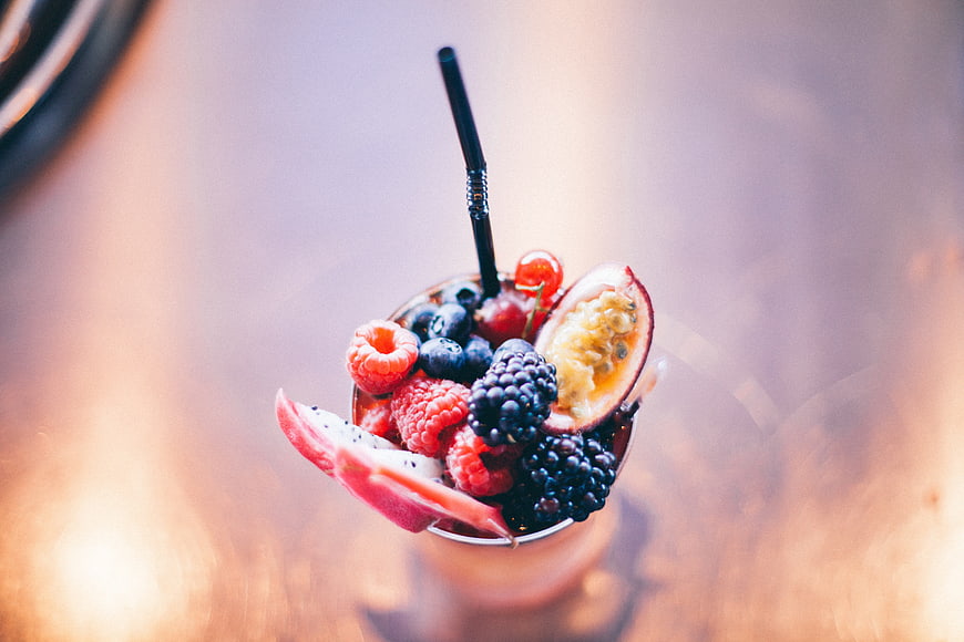 Overhead view of berry smoothie with fresh fruit garnish