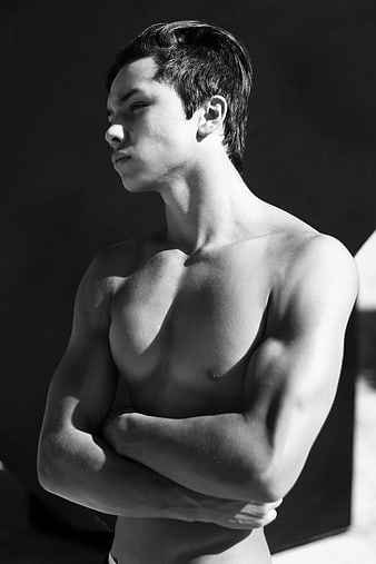 Black and white portrait of a muscular Asian man with arms crossed