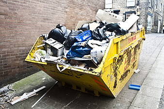Yellow Skip Bin Full of Rubbish on Urban Street
