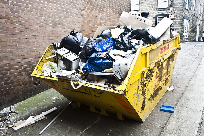 Yellow Skip Bin Full of Rubbish on Urban Street