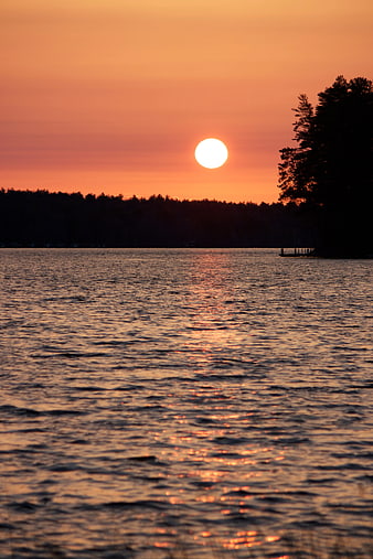 Sunset over Lake with Silhouetted Trees and Dock