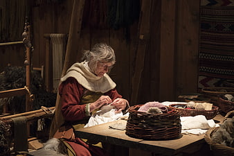 Senior Woman Sewing in Traditional Viking Attire
