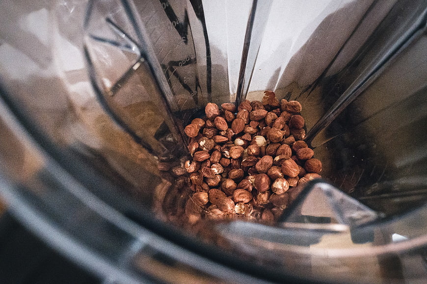 Top-down view of hazelnuts in a blender jar