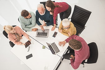 Overhead view of diverse business team meeting around white table