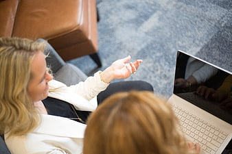 Two women collaborating on laptop in office meeting