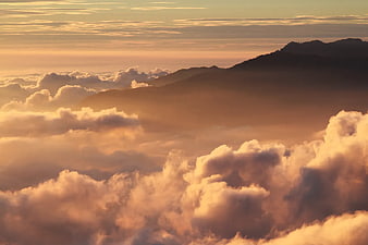 Golden Sunset Over Mountain Peaks and Sea of Clouds