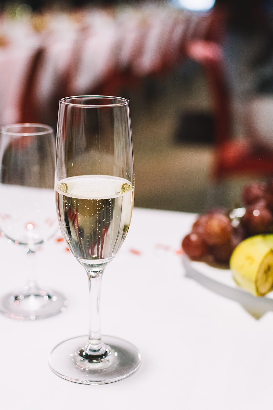 Glass of champagne on a white table with fruit