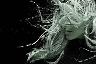 Dramatic Portrait of Woman with Windblown Hair Against Black Background