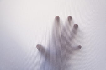Blurry hand silhouette behind frosted glass