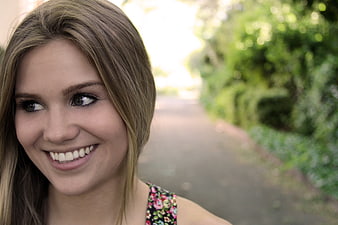 Close-up portrait of smiling blonde woman outdoors