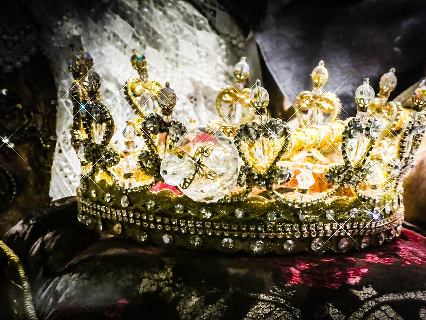 Ornate gold crown with crystals on velvet